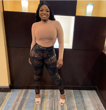 Load image into Gallery viewer, Black snake print leggings styled with crop top and heels for a chic streetwear outfit.