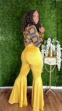 Load image into Gallery viewer, Styled mustard shiny bellbottom pants paired with fitted crop top for chic casual outfit.
